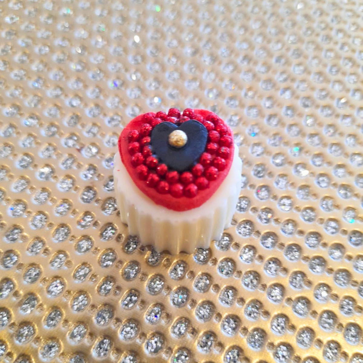 white chocolate hearts with a black and red fondant heart with edible gold nuggets