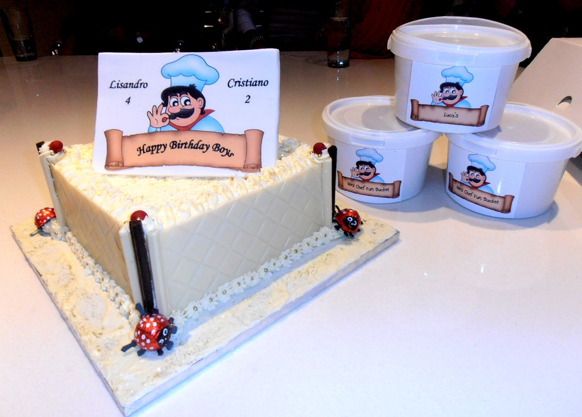 white chocolate cake with vanilla frosting trimmings and chef themed party packs