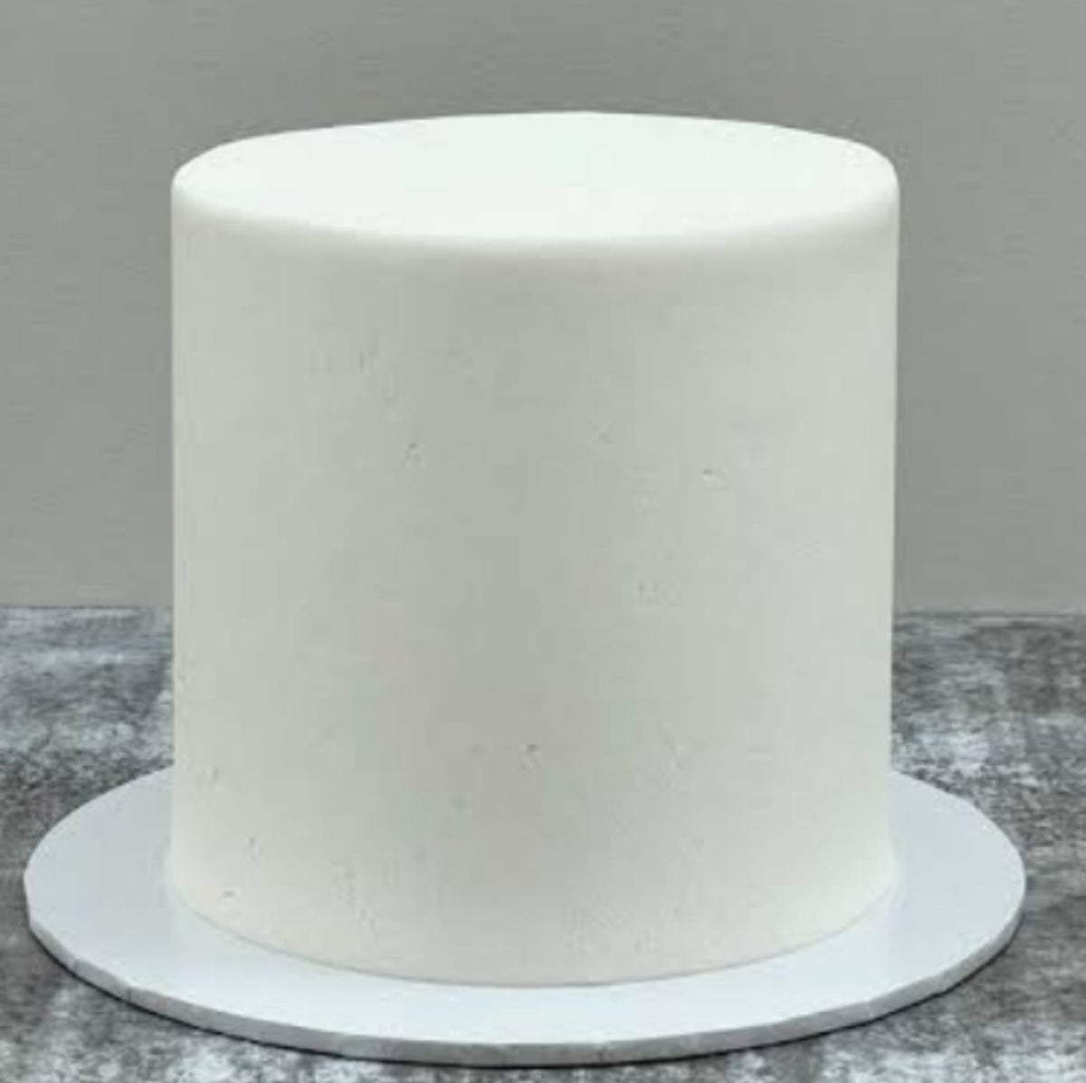 White cylindrical fondant cake