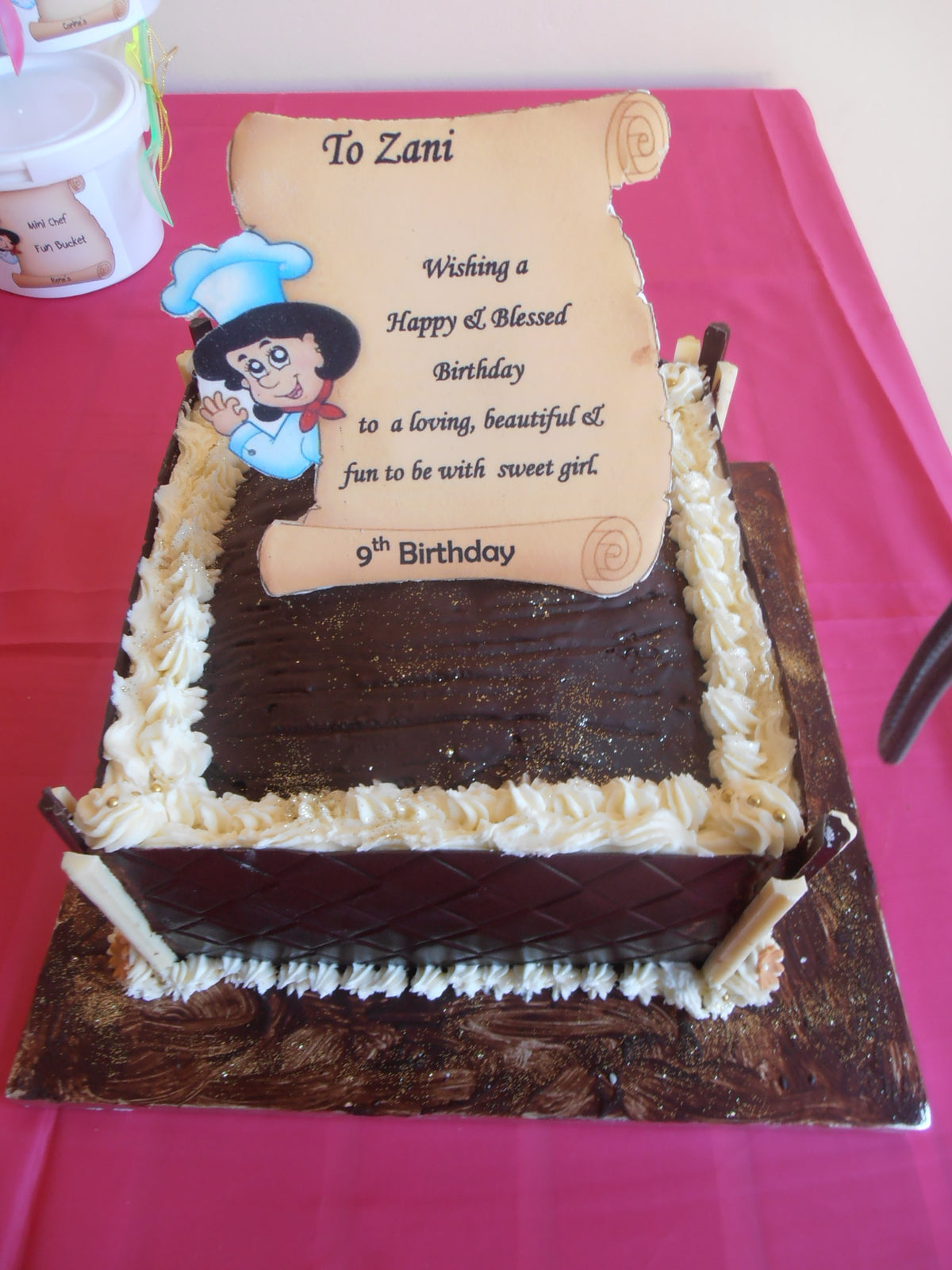 Dark chocolate cake with white trimmings and an edible cake scroll with edible print